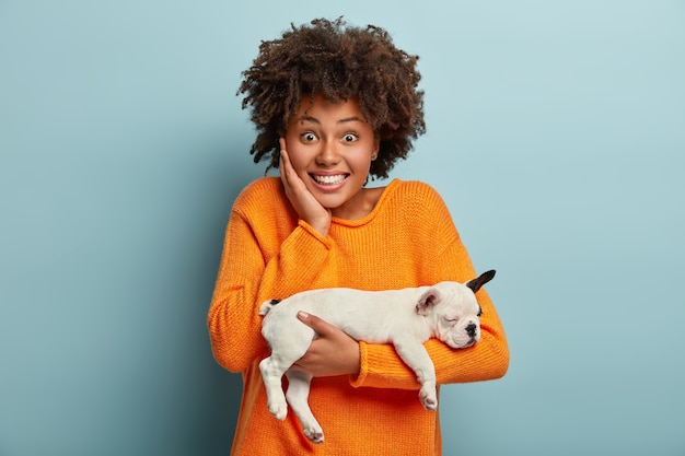 Young woman with Afro haircut holding puppy