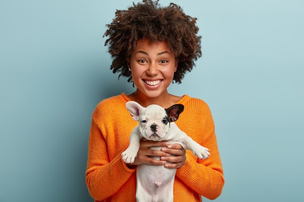 Young woman with Afro haircut holding puppy