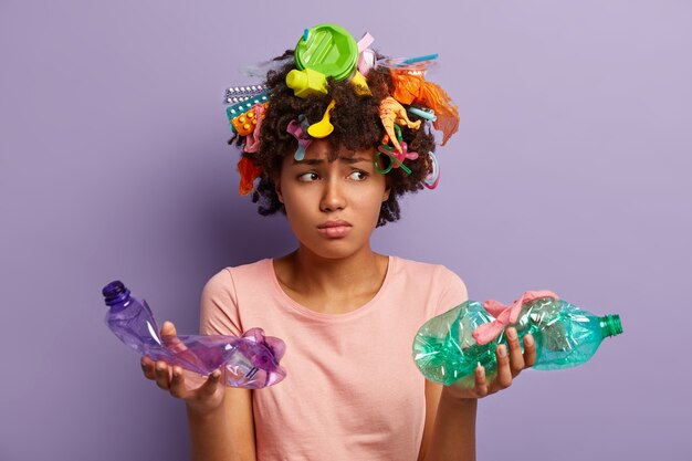 アフロヘアカットと髪のプラスチック廃棄物を持つ若い女性