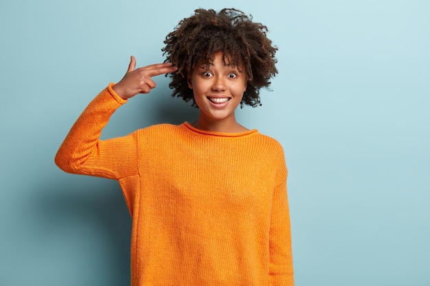 Free photo young woman with afro haircut wearing orange jumper