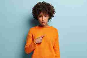 Foto gratuita giovane donna con taglio di capelli afro che indossa il ponticello arancione