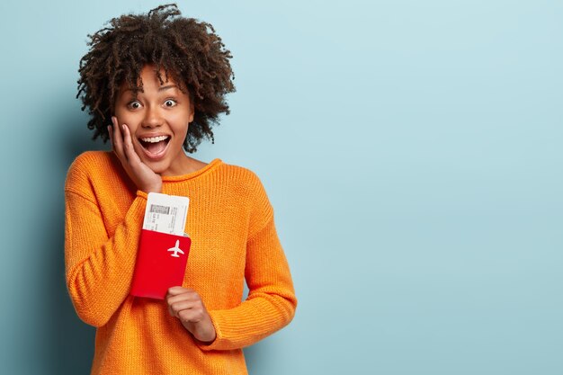 Young woman with Afro haircut wearing orange sweater