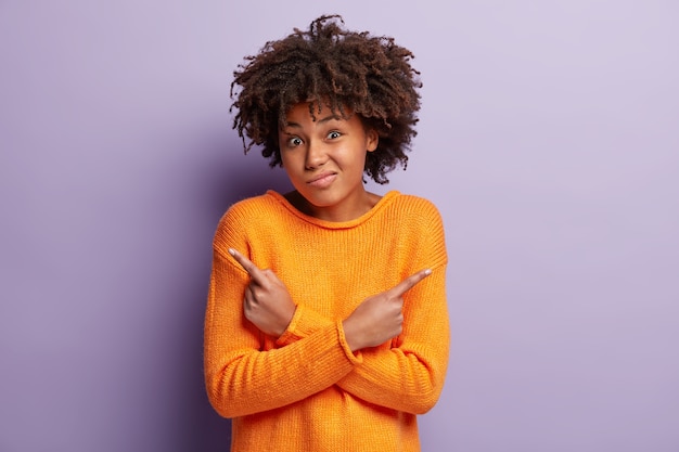 Free photo young woman with afro haircut wearing orange sweater