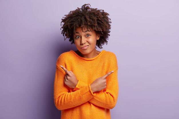 Молодая женщина с афро-стрижкой в оранжевом свитере