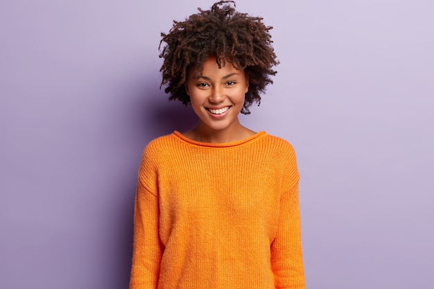 Foto gratuita giovane donna con taglio di capelli afro che indossa un maglione arancione