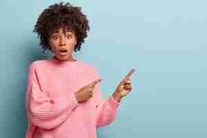 Free photo young woman with afro haircut wearing pink sweater