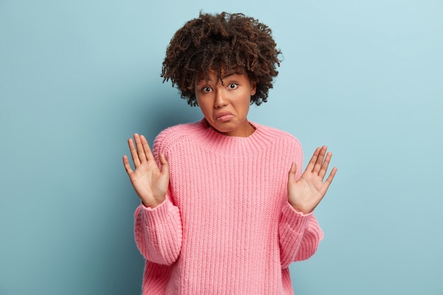 Free photo young woman with afro haircut wearing pink sweater