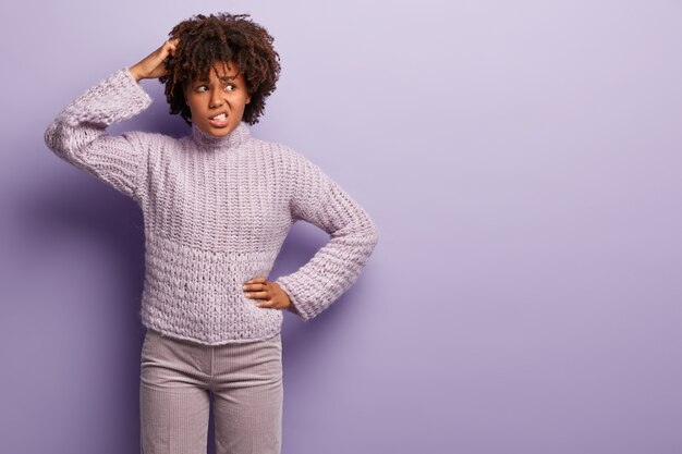 Young woman with Afro haircut wearing purple sweater