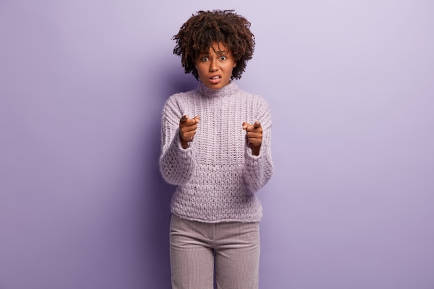 Young woman with afro haircut wearing purple sweater