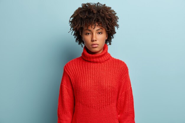 빨간 스웨터를 입고 아프로 머리를 가진 젊은 여자