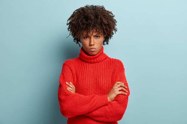 赤いセーターを着てアフロヘアカットの若い女性