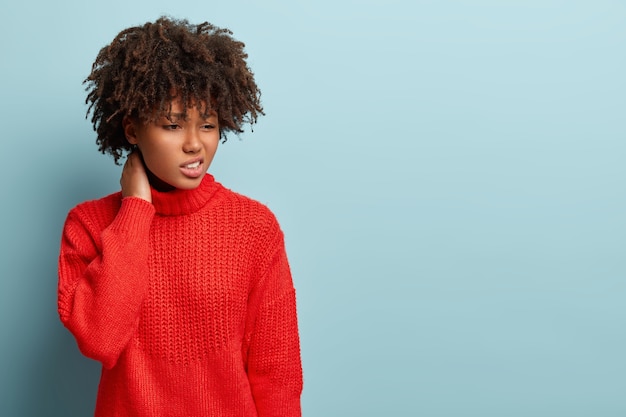 Young woman with Afro haircut wearing red sweater