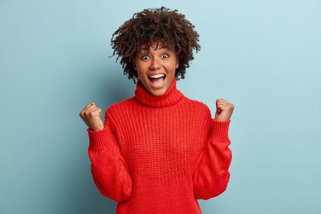 Young woman with Afro haircut wearing red sweater