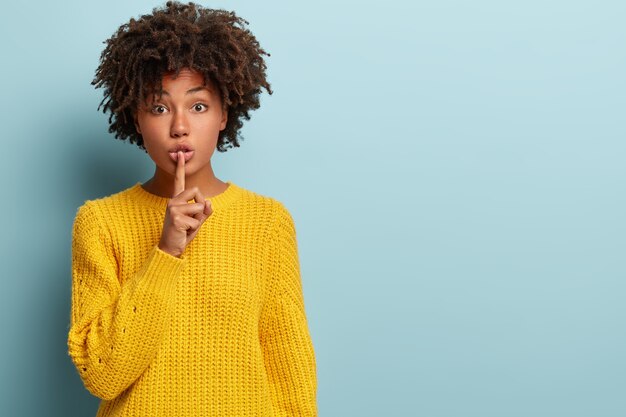 セーターを着てアフロヘアカットの若い女性