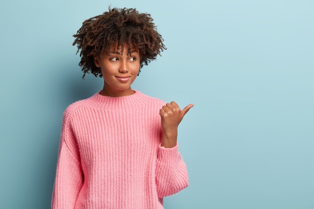 Young woman with Afro haircut wearing sweater