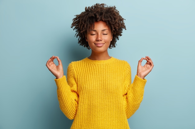 Young woman with Afro haircut wearing sweater