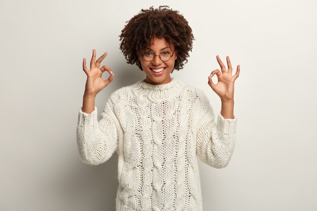 白いセーターを着てアフロヘアカットの若い女性