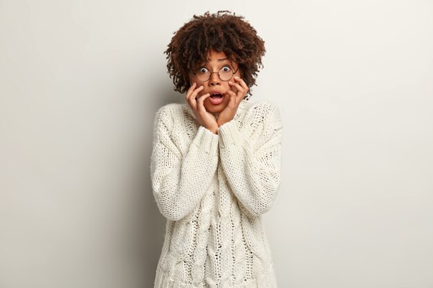 Young woman with Afro haircut wearing white sweater