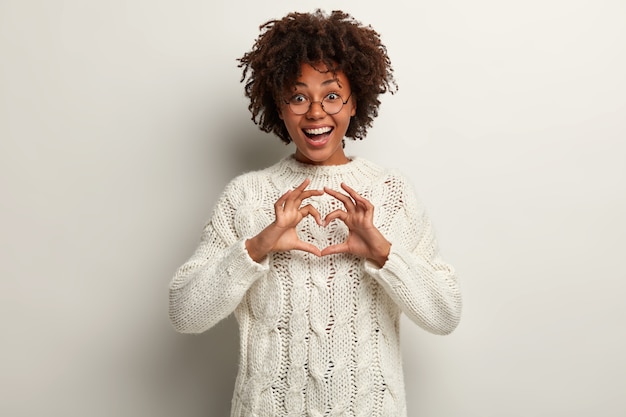 Free photo young woman with afro haircut wearing white sweater