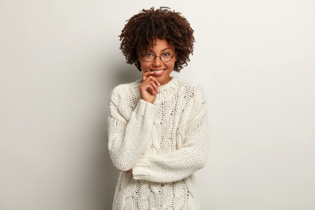 Young woman with Afro haircut wearing white sweater