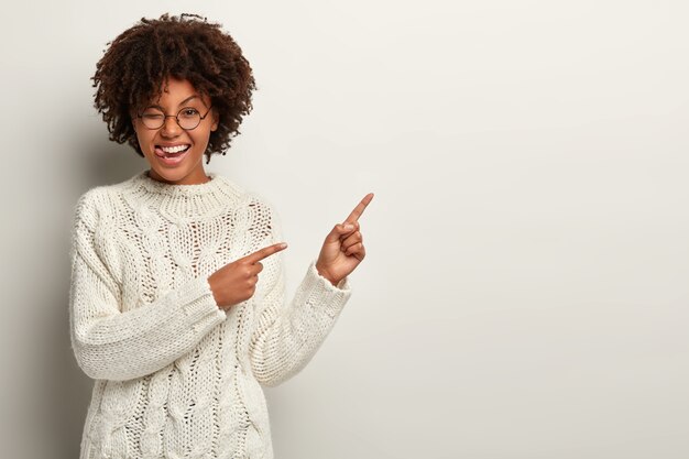 Young woman with Afro haircut wearing white sweater