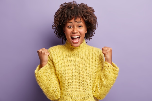 Young woman with Afro haircut wearing yellow sweater