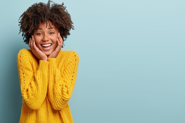 Young woman with Afro haircut wearing yellow sweater