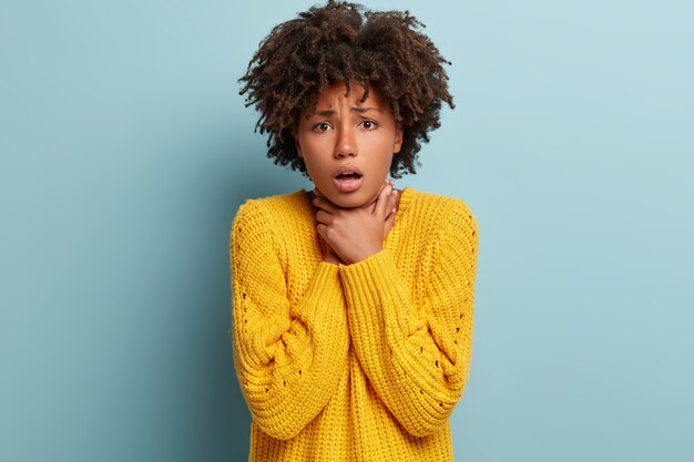 Young woman with Afro haircut wearing yellow sweater