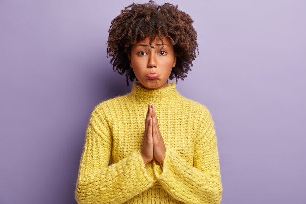 Young woman with Afro haircut wearing yellow sweater