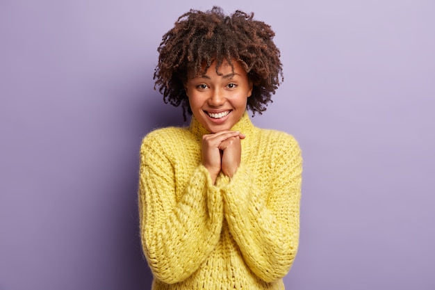 Young woman with Afro haircut wearing yellow sweater