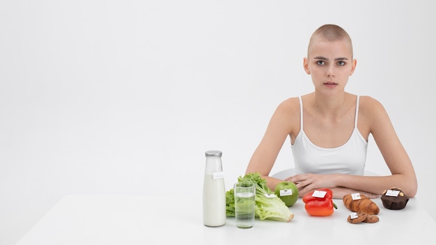 カロリー数の食品の横にある摂食障害の若い女性 無料写真