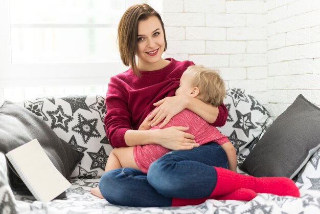Молодая женщина с ребенком на диване