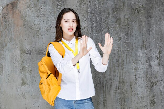 Young woman with backpack showing her hands. High quality photo