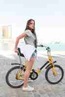 Free photo young woman with bicycle looking away