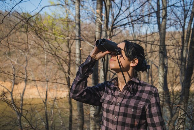 Young woman with binoculars outdoors