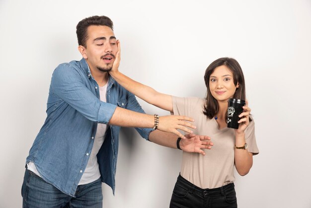 Young woman with black cup repelling a man.