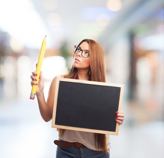 Young woman with blackboard and pencil