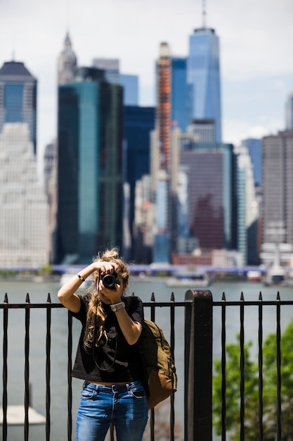 Foto gratuita giovane donna con sfondo sfocato città