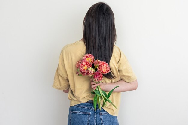 A young woman with a bouquet of flowers on a white background