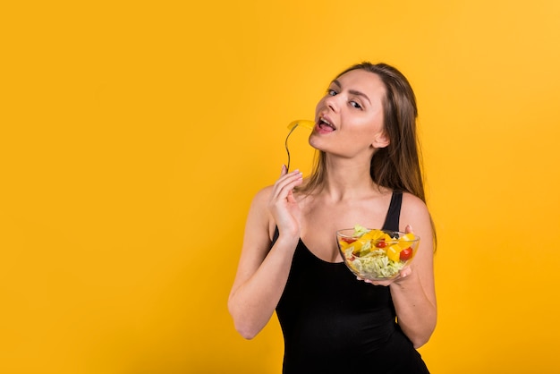 Free photo young woman with bowl of salad