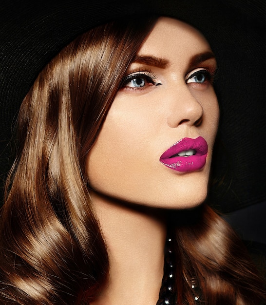 Young woman with bright makeup and black hat