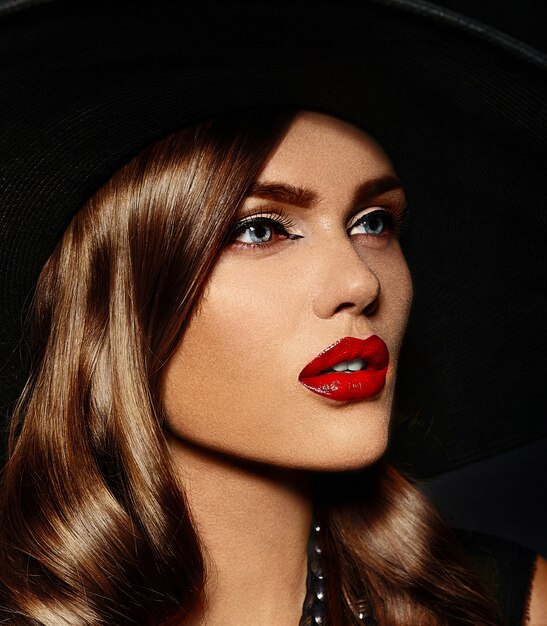 young woman with bright makeup and black hat