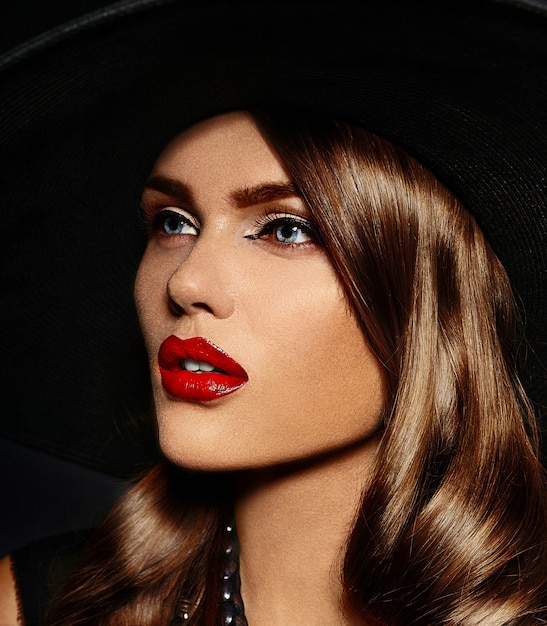 Young woman with bright makeup and black hat