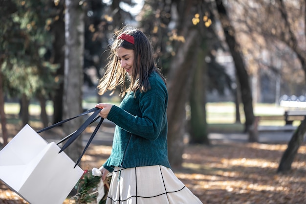 Free photo young woman with christmas gifts outside christmas shopping