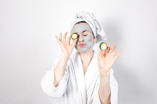 A young woman with a clay mask on her face