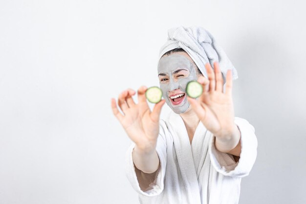 A young woman with a clay mask on her face