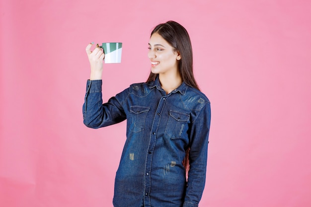 Giovane donna con una tazza di caffè che sorride e che si sente positiva