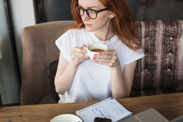 Young woman with coffee cup at table