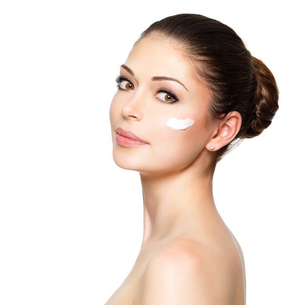 Young woman with cosmetic  cream on a clean fresh face