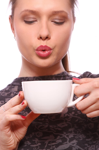 Молодая женщина с чашкой горячего кофе